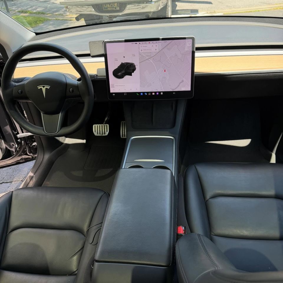 Spotless Tesla Model Y cabin with clean black leather seats and center console after a Wilmington-area interior detail