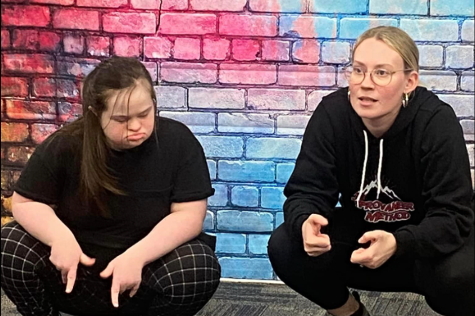 Participant with Down syndrome and instructor practicing expressive movement during an Improvaneer Method class.