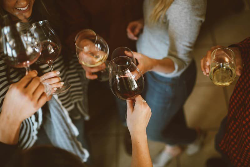 People clinking their wine glasses together 