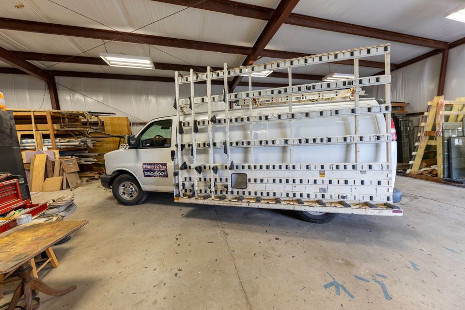 Wide side view of a glass service truck and full exterior transport rack in the workshop