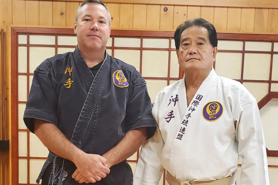 Hanshi Seiken Takamine posing with a student at Takamine Karate Dojo in Miller Place