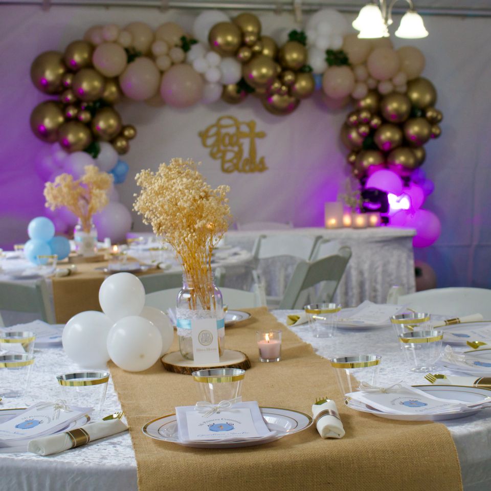 Gold balloon garland backdrop and styled tables for a tented First Communion celebration in the Hamptons