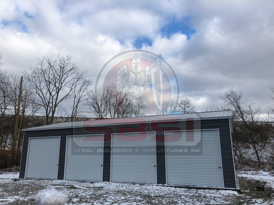 Blue steel garage with white roll up doors in snowy lot with SBSI watermark representing steel garages in Alabama