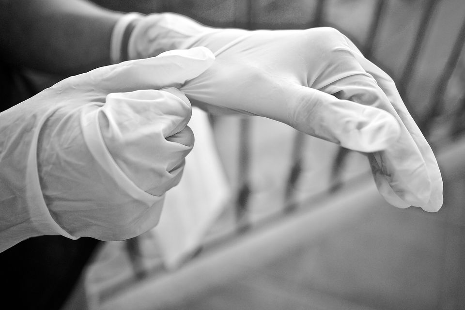 Someone wearing white latex cleaning gloves