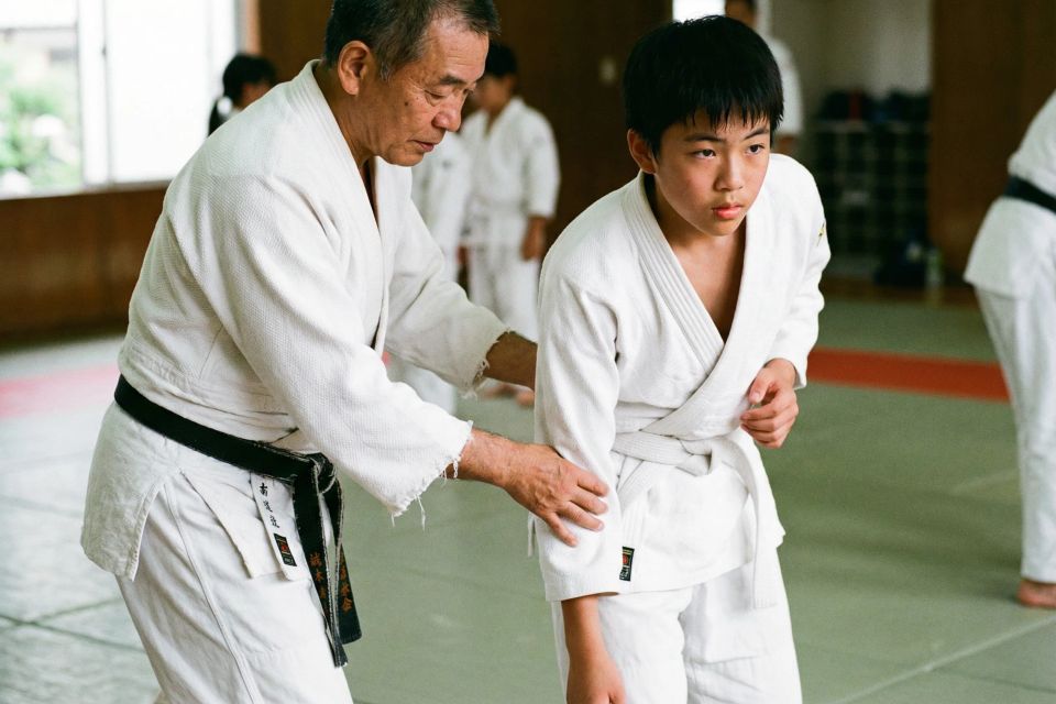  Sensei teaching young boy judo technique in dojo martial arts class for kids