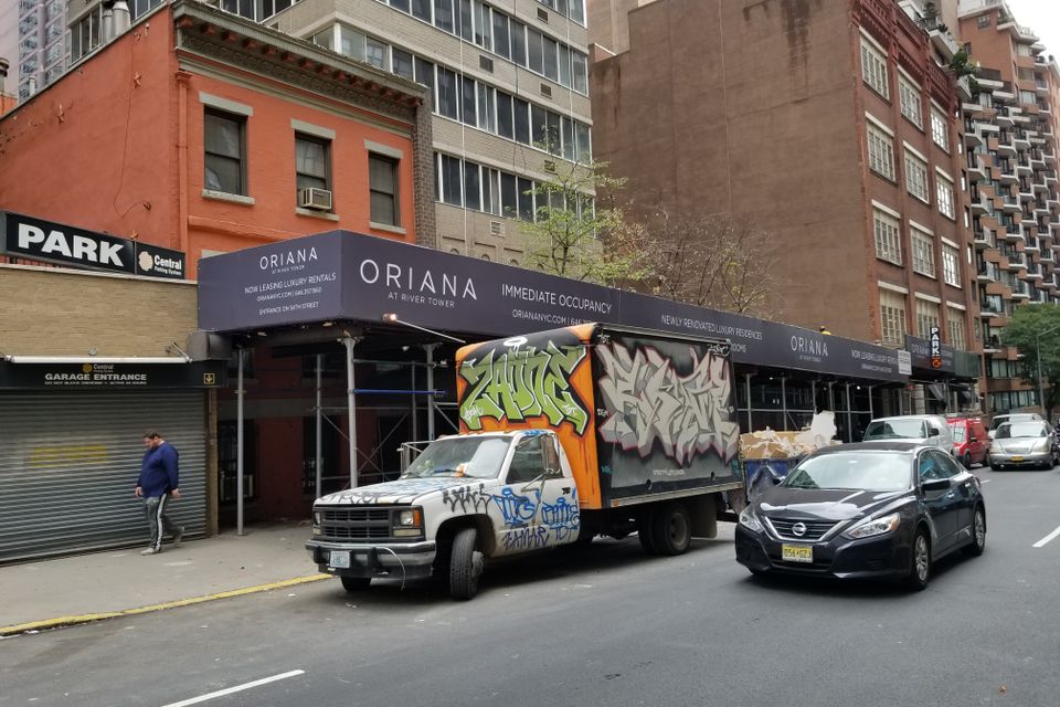 Printed banner running the full length of a sidewalk shed on a Manhattan block