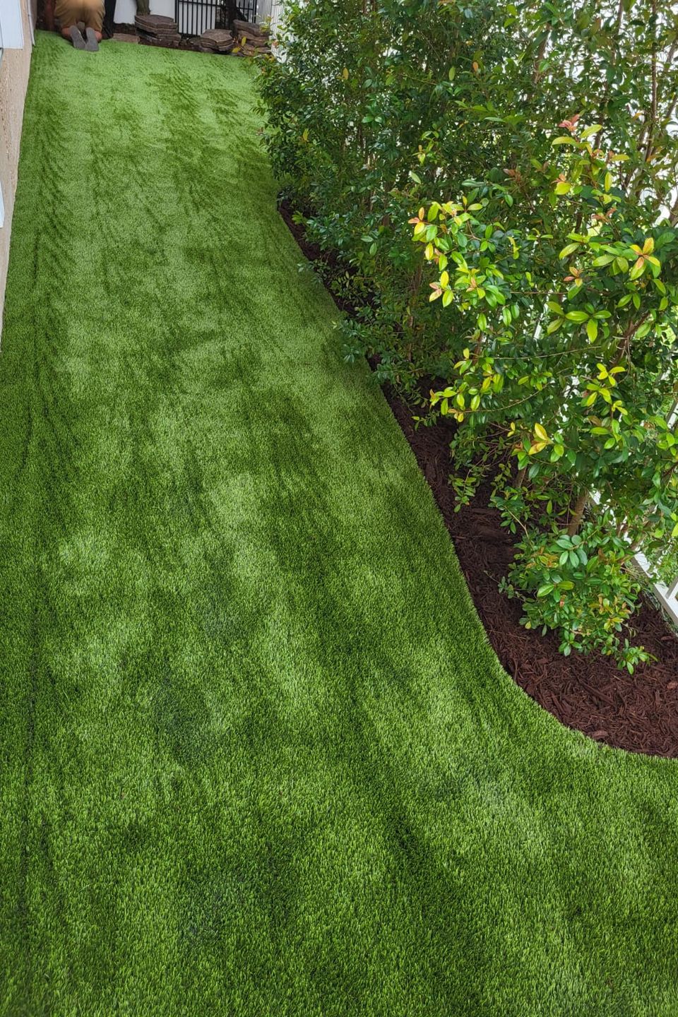 Installing fake grass near pink house