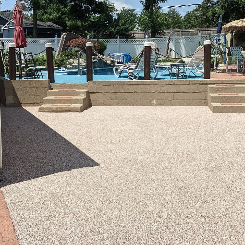 Backyard pool deck finished with an EverStone Flex textured coating surrounding a swimming pool.