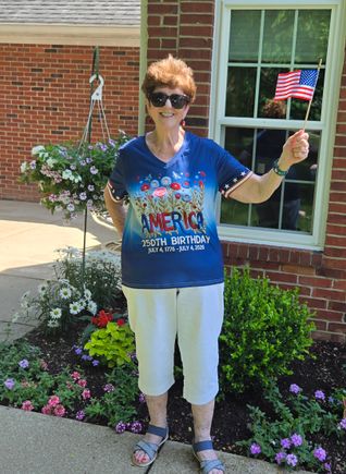 Woman celebrating America’s 250th birthday while holding a small American flag.