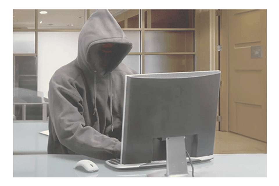 Hooded figure on computer