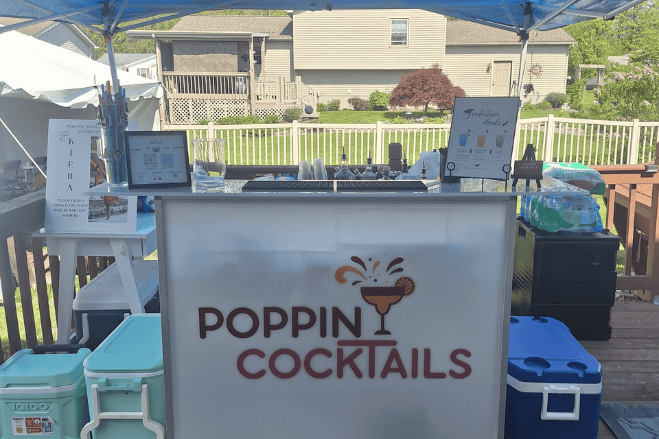 Poppin Cocktails 4ft light-up portable bar set up for beverage service at an outdoor graduation celebration.
