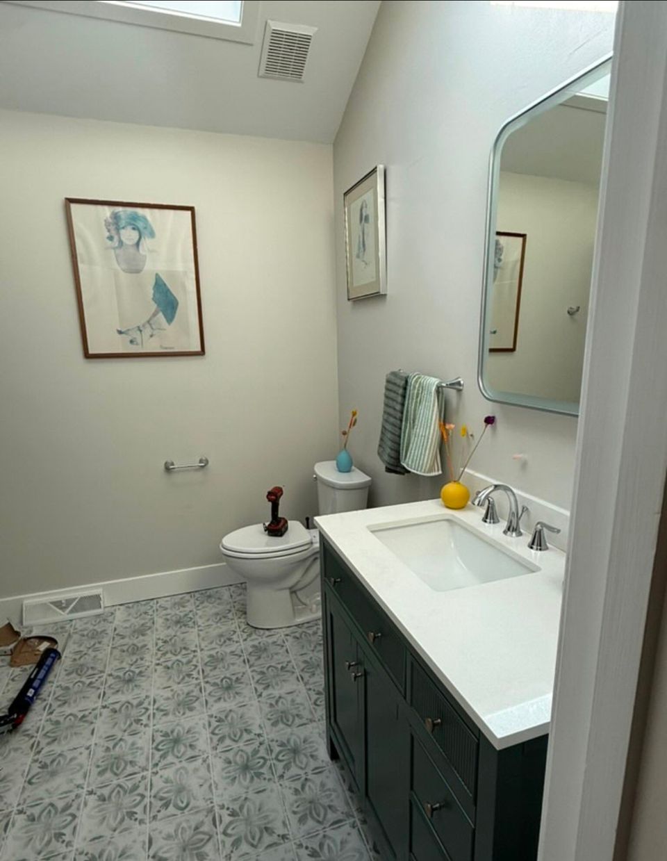 Powder room remodel with dark green vanity, quartz top, and patterned tile floor in Cleveland Heights