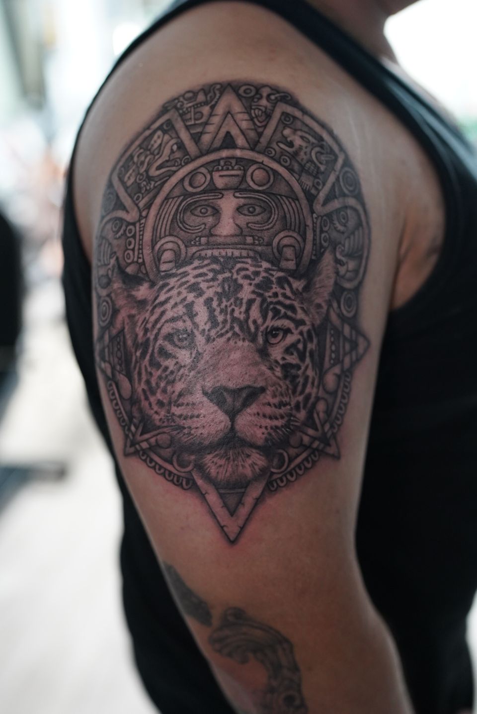 Image of a tattoo representing a jaguar and mayan symbols surrounding the very detailed jaguar