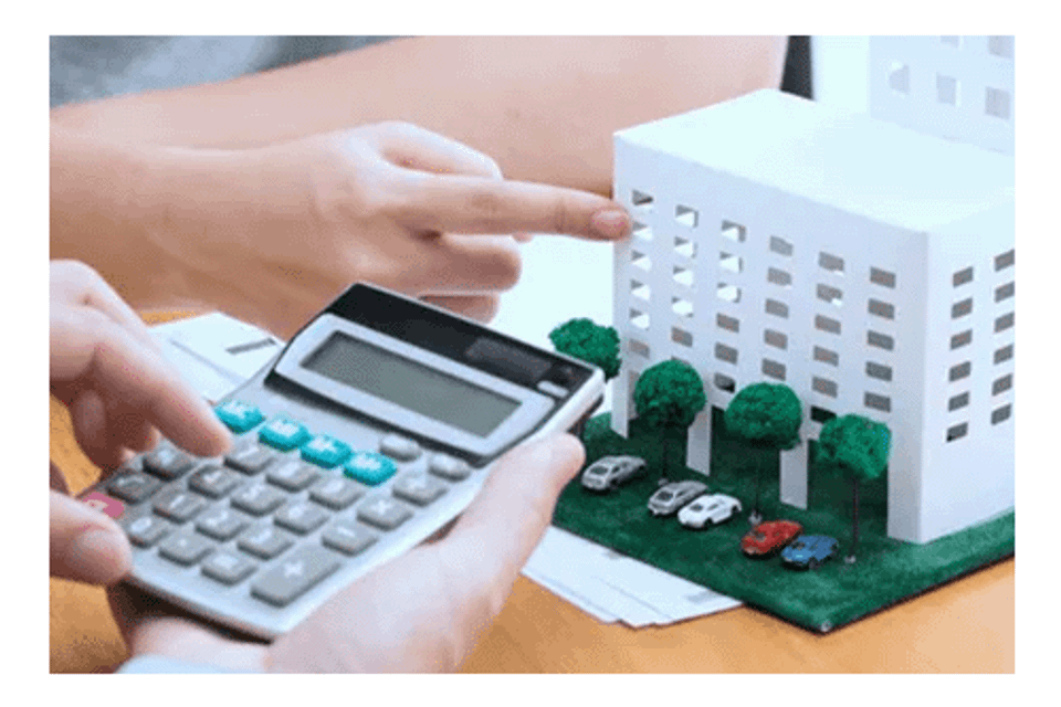 Man pointing to model condo with insurance agent holding calculator