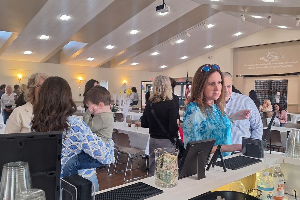 Guests at a bar with drinks, mixers, and garnishes at a retirement party