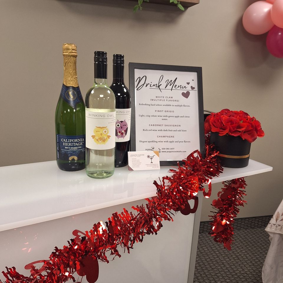 Close-up of drink menu, wine bottles, and Valentine-themed bar setup with red decor